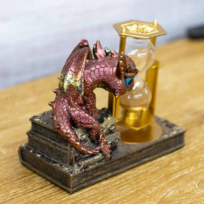 Visão frontal da ampulheta com areia fina e o pequeno dragão vermelho, destacando o design de fantasia e mitologia.